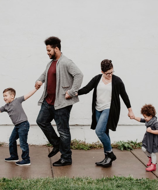 a family holding hands and walking together